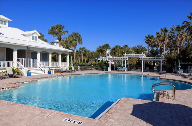 pool with a patio area and a pergola