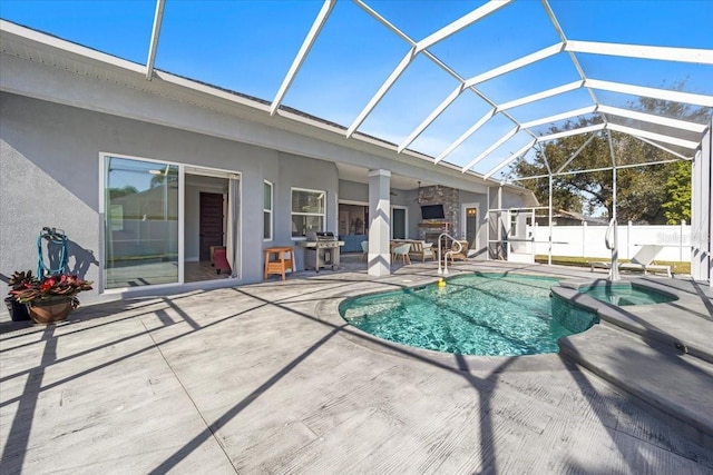 view of swimming pool featuring a patio, fence, a pool with connected hot tub, grilling area, and a lanai