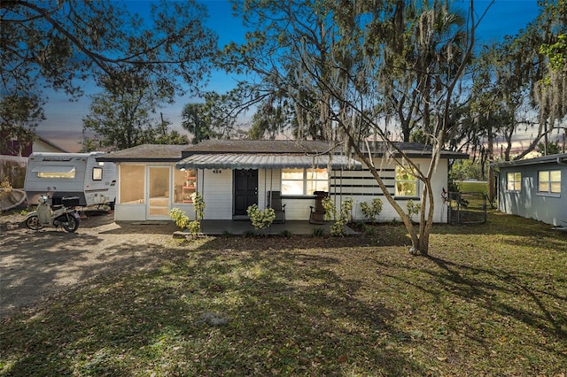 rear view of house featuring a porch and a yard