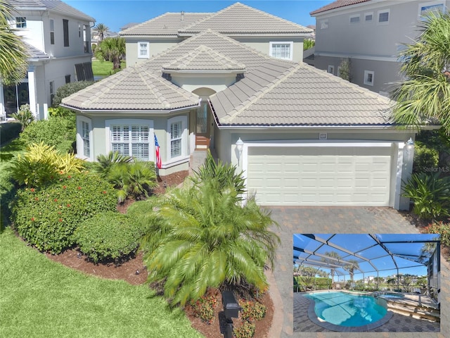 mediterranean / spanish-style home featuring an attached garage, a tile roof, stucco siding, driveway, and an outdoor pool