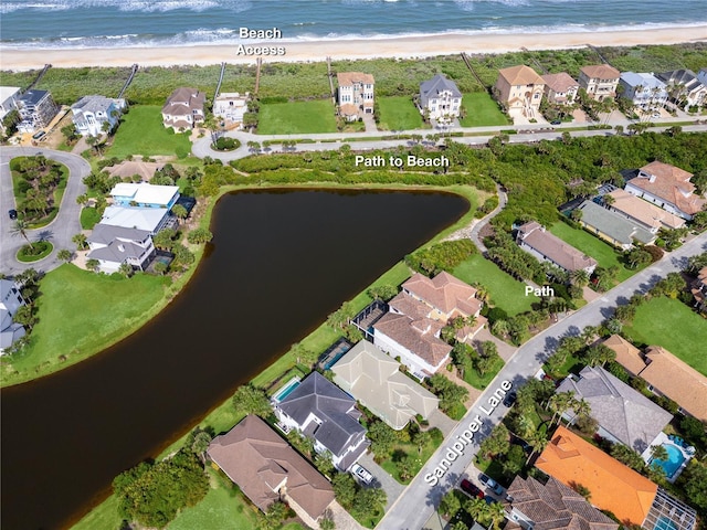 aerial view with a residential view, a view of the beach, and a water view