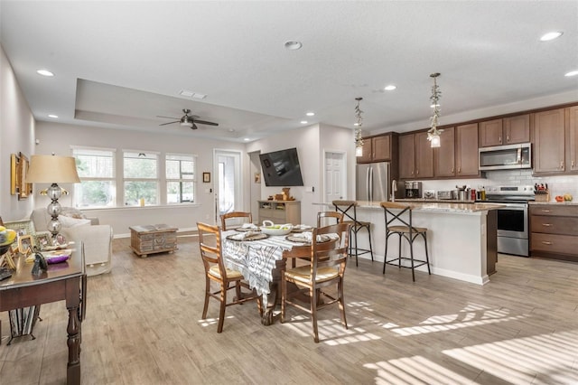 dining space with recessed lighting, visible vents, light wood-style flooring, a ceiling fan, and baseboards