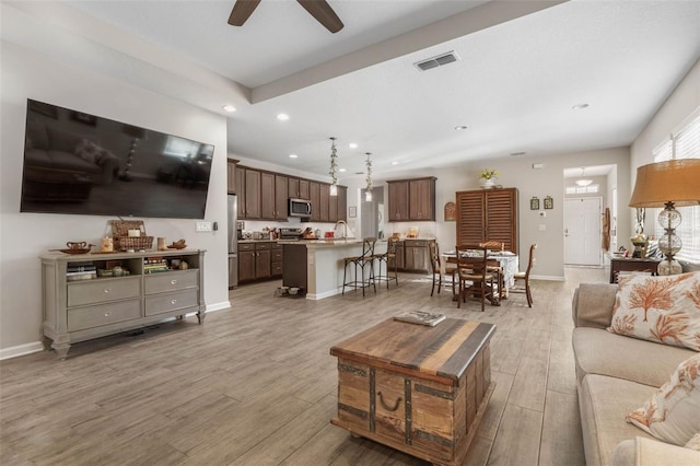 living area featuring recessed lighting, baseboards, visible vents, and light wood finished floors