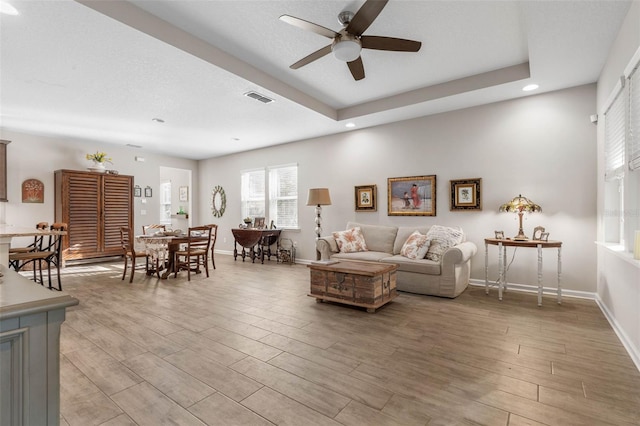 living room featuring light wood-style flooring, recessed lighting, a ceiling fan, visible vents, and baseboards