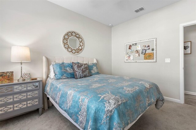 bedroom with carpet floors, visible vents, and baseboards