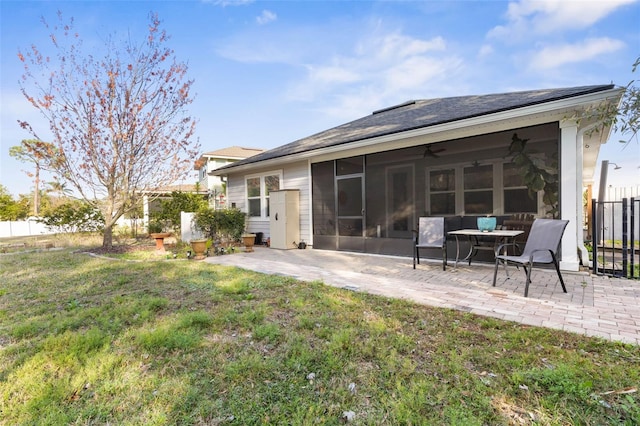 rear view of house with a patio area, fence, a sunroom, and a lawn