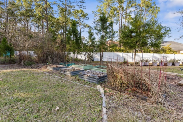 view of yard with a vegetable garden and fence