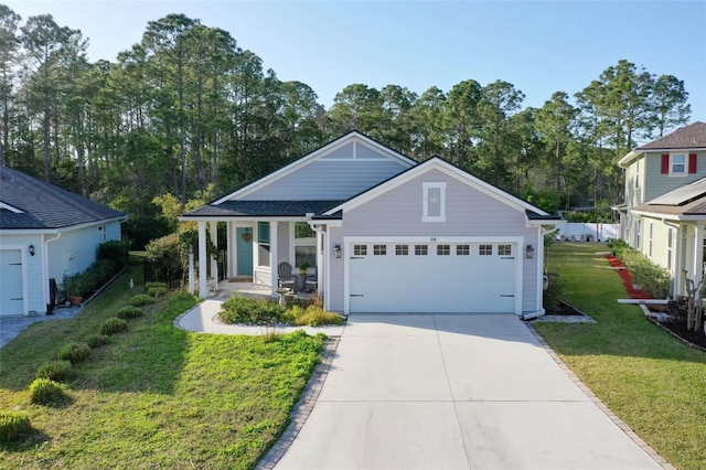 view of front of house featuring an attached garage, a porch, concrete driveway, and a front yard