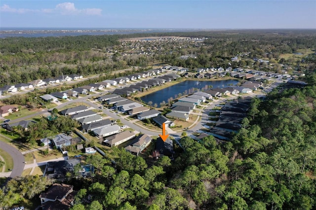 drone / aerial view with a water view, a residential view, and a view of trees