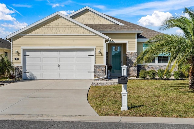 craftsman house featuring a front yard, driveway, roof with shingles, stone siding, and a garage