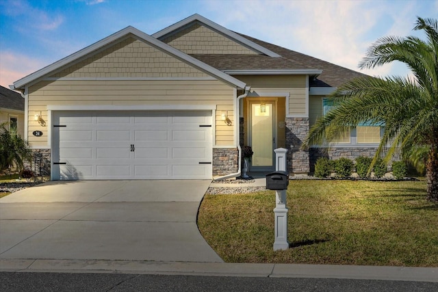 craftsman inspired home with a shingled roof, a lawn, a garage, stone siding, and driveway