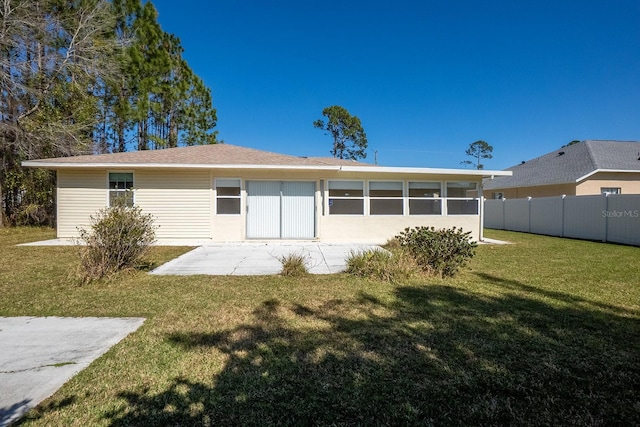 rear view of property with a patio area, fence, and a lawn