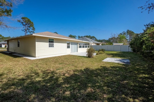 back of property with a patio area, fence, and a lawn