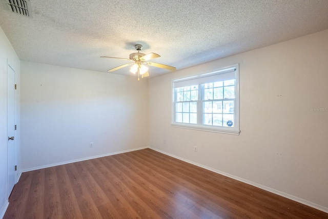 empty room with visible vents, baseboards, ceiling fan, and wood finished floors