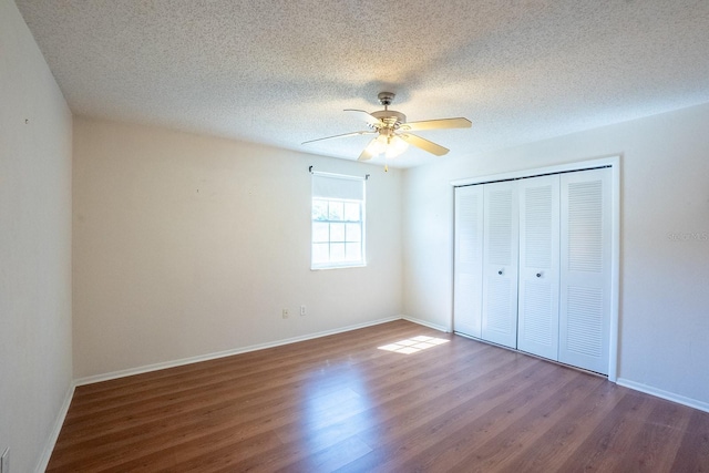 unfurnished bedroom featuring ceiling fan, baseboards, wood finished floors, a closet, and a textured ceiling