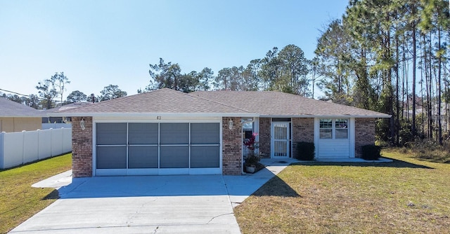 single story home with brick siding, fence, concrete driveway, a front yard, and a garage