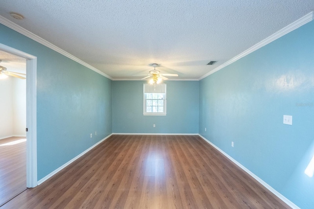 unfurnished room with visible vents, crown molding, a ceiling fan, and wood finished floors