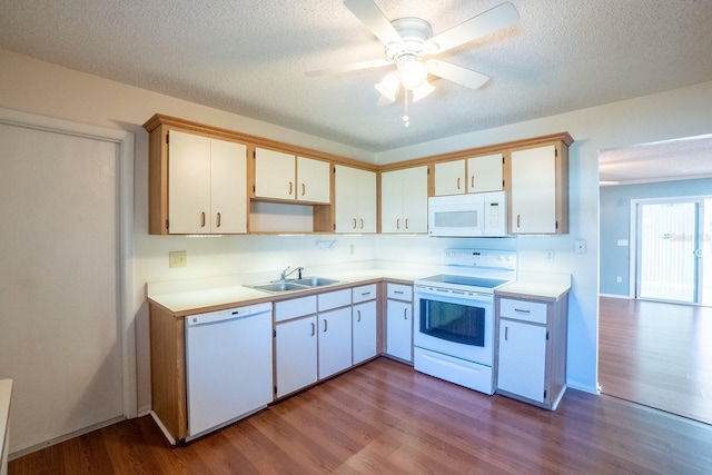 kitchen with a sink, white appliances, dark wood-style flooring, and light countertops