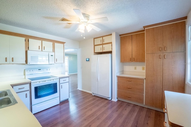 kitchen with white appliances, wood finished floors, a sink, light countertops, and a textured ceiling