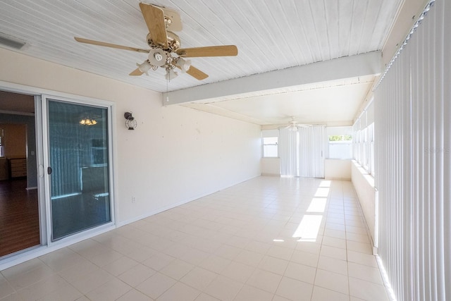 tiled empty room featuring beamed ceiling, a ceiling fan, and visible vents