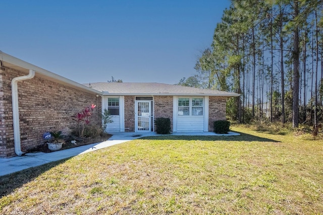 single story home with brick siding and a front yard