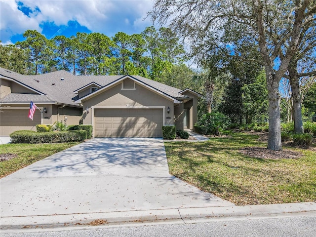 view of front of home featuring a garage, concrete driveway, a front yard, and stucco siding