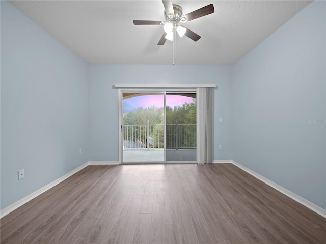 spare room with ceiling fan, wood finished floors, and baseboards