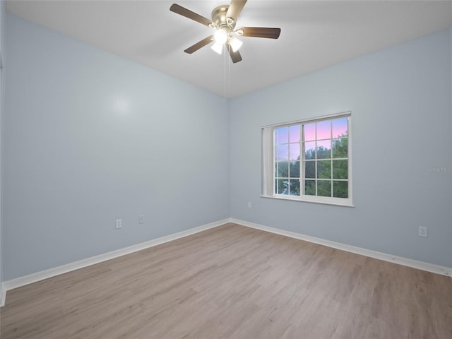 unfurnished room with ceiling fan, baseboards, and wood finished floors