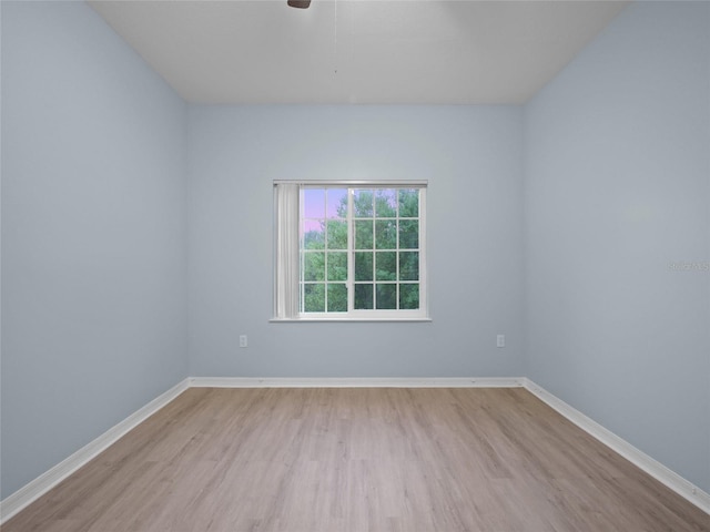 empty room with ceiling fan, baseboards, and wood finished floors