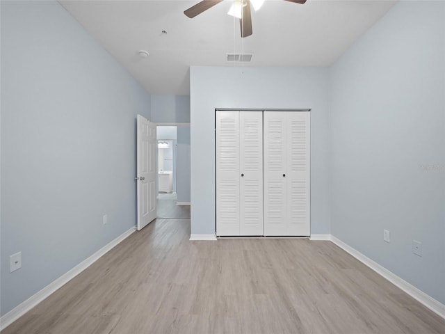 unfurnished bedroom featuring baseboards, visible vents, light wood-style flooring, ceiling fan, and a closet