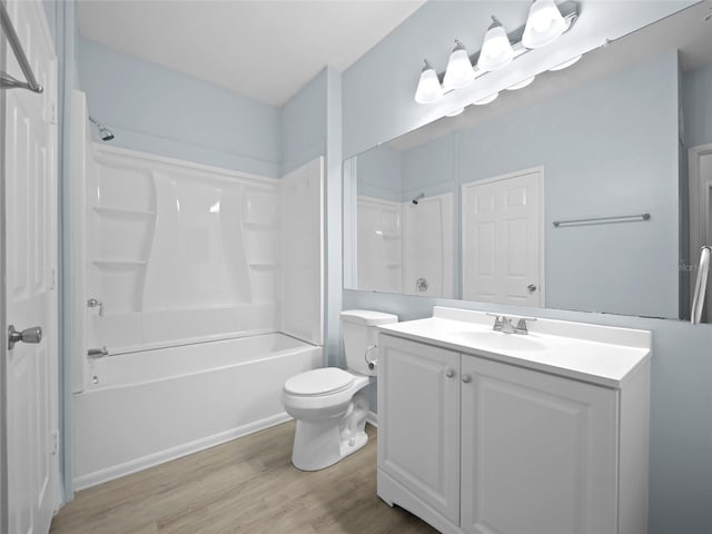 bathroom with toilet, vanity, wood finished floors, and washtub / shower combination