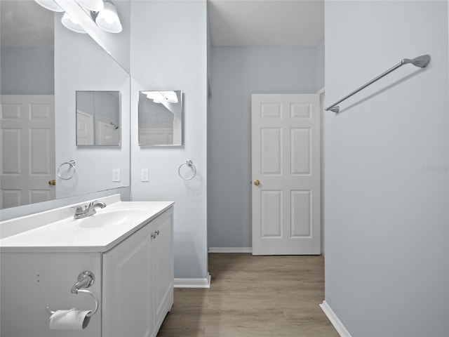 bathroom featuring vanity, baseboards, and wood finished floors