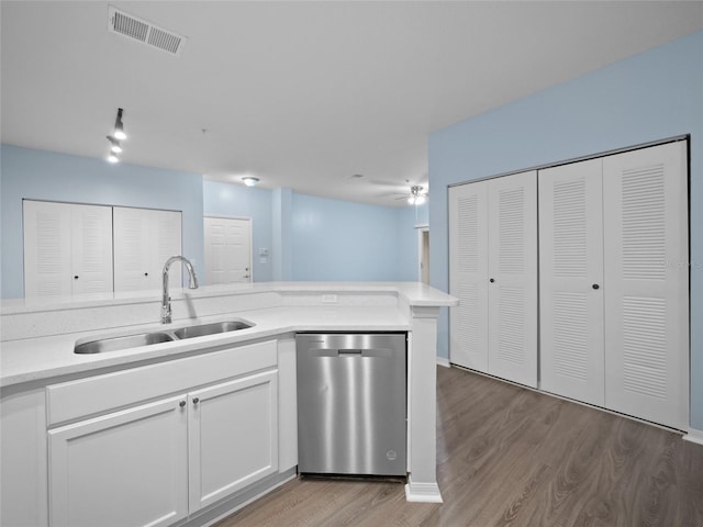 kitchen with light countertops, visible vents, light wood-style flooring, a sink, and dishwasher