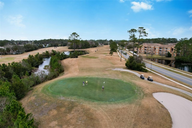 drone / aerial view with a water view and golf course view