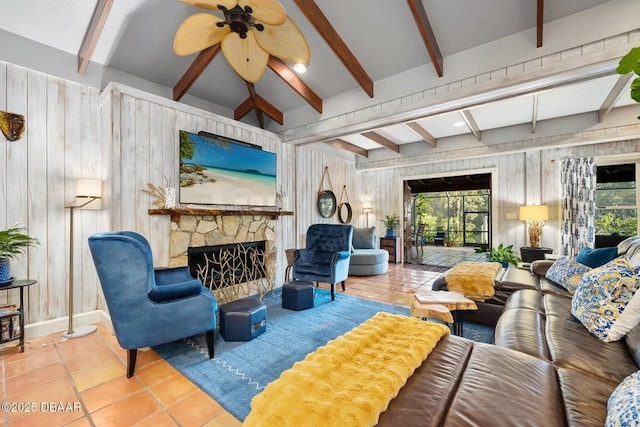 living area with wooden walls, beamed ceiling, a stone fireplace, and tile patterned floors