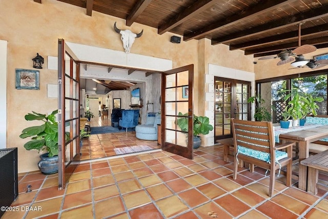 sunroom with beam ceiling, wood ceiling, french doors, and a ceiling fan