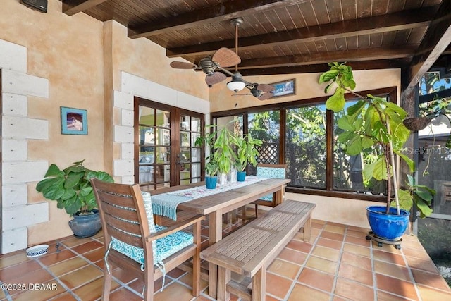 sunroom / solarium featuring a ceiling fan, wooden ceiling, beamed ceiling, and french doors