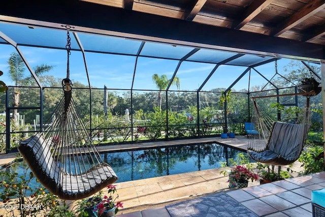 outdoor pool featuring glass enclosure and a patio area