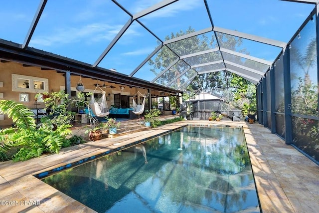 pool with ceiling fan, a patio, and glass enclosure