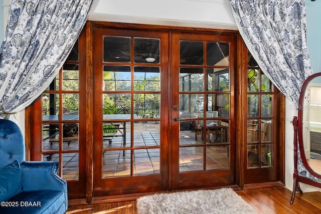 doorway to outside featuring arched walkways, french doors, and wood finished floors