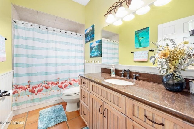 bathroom featuring tile patterned flooring, toilet, vanity, wainscoting, and shower / bath combination with curtain