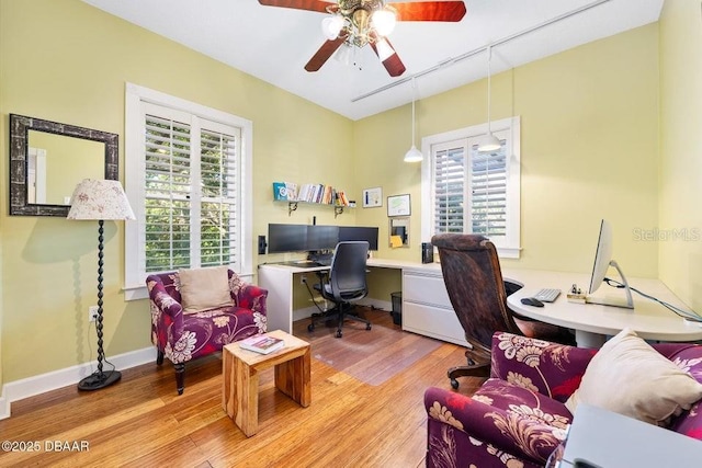 office featuring light wood-style floors, rail lighting, ceiling fan, and baseboards