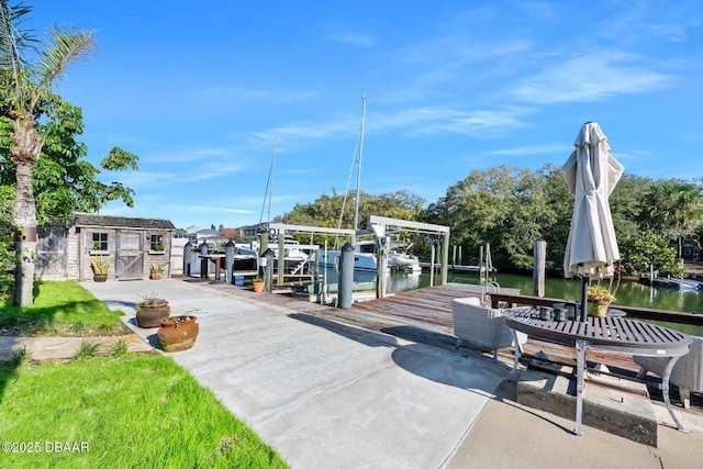 view of home's community featuring a boat dock, boat lift, and an outdoor structure