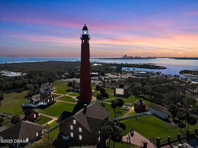 aerial view at dusk featuring a water view