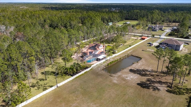 birds eye view of property featuring a water view and a wooded view