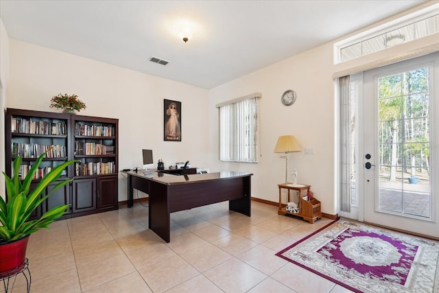 home office with light tile patterned floors, visible vents, and baseboards