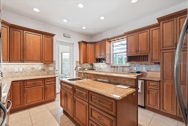 kitchen featuring a center island with sink, open shelves, brown cabinetry, light tile patterned flooring, and a sink