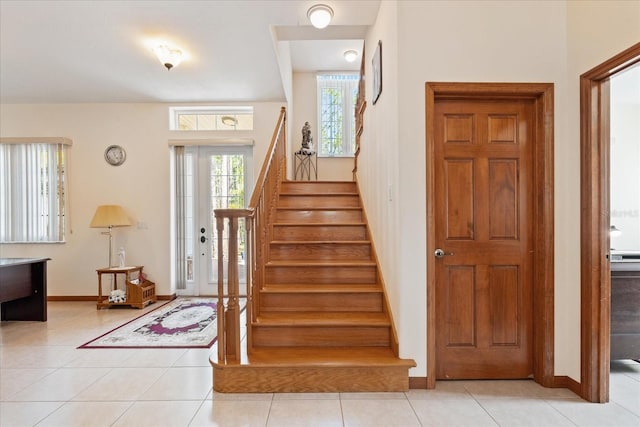 staircase featuring tile patterned flooring and baseboards