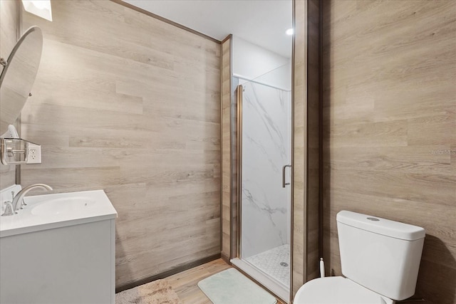 full bathroom with wood finished floors, a shower stall, toilet, and vanity