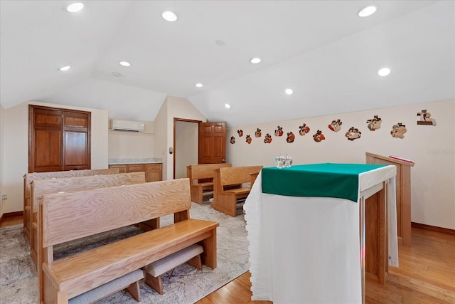 dining space featuring baseboards, lofted ceiling, an AC wall unit, light wood-style floors, and recessed lighting